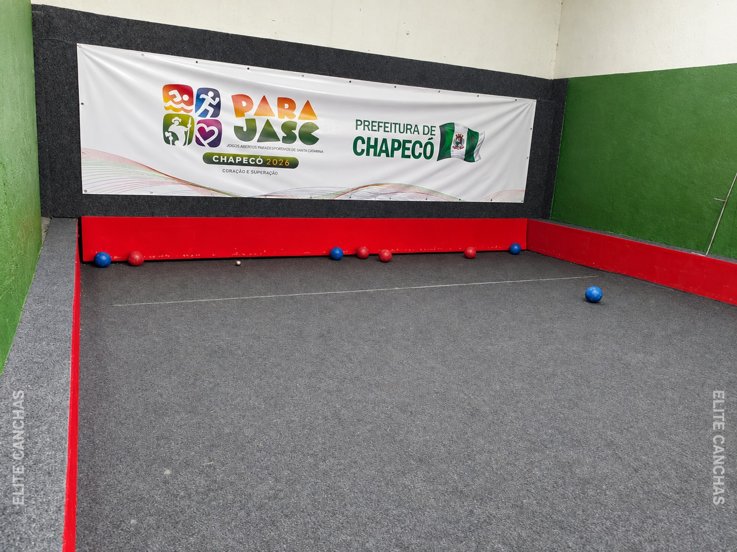 Bochas na cabeceira da cancha da Cidade do Idoso; ao fundo, faixa do PARAJASC Chapecó 2026.